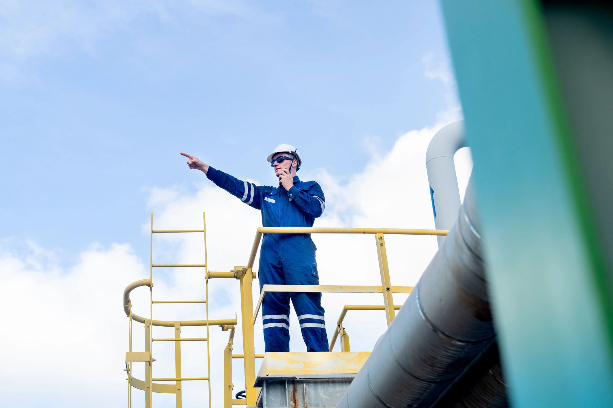 Oilfield technician inspecting operations and communicating by radio